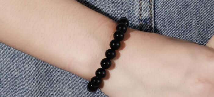 Black Onyx Bracelet worn on a wrist, featuring smooth black agate beads, stylish and geometric design.