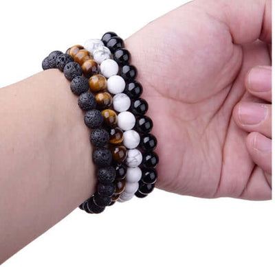 Hand wearing multiple bracelets including a stylish Black Onyx Bracelet.