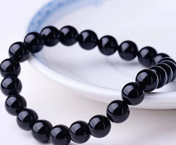 Black Onyx Bracelet on a plate showcasing its geometric design and health benefits.