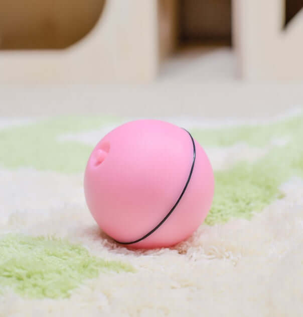 LED Laser Electronic Rolling Pet Funny Cat Toy Ball in pink color on a soft carpet.