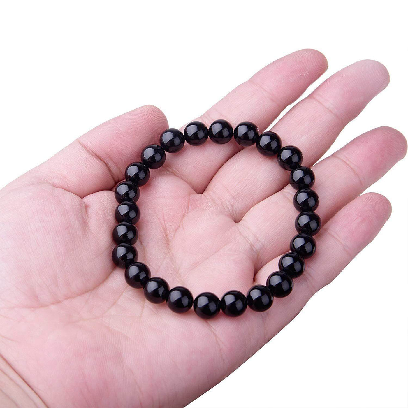 Black Onyx Bracelet held in a hand, featuring shiny black agate beads in a geometric style.