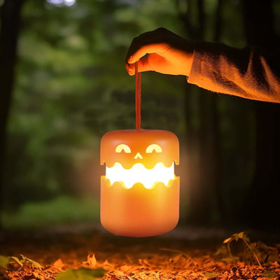 Halloween Pumpkin Lamp Foldable Portable Small Night Lamp being held in a forest.