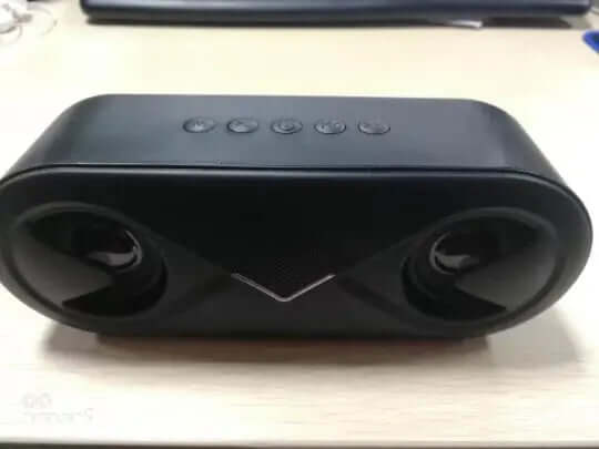 Wireless bluetooth speaker with dual speakers and control buttons on top.