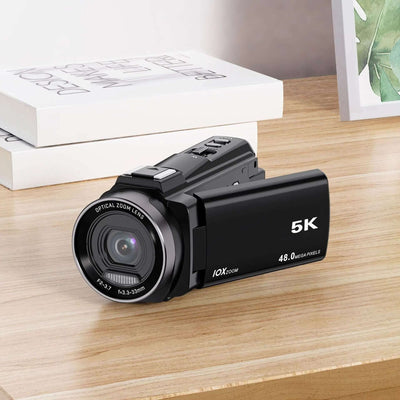 HD Digital Optical Zoom Camera Outdoor Sports DV Camera on a wooden table with books.