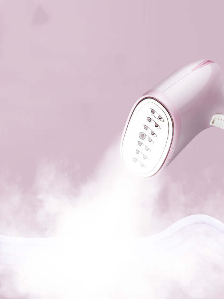 Handheld garment steamer household steam iron releasing steam against a soft background.